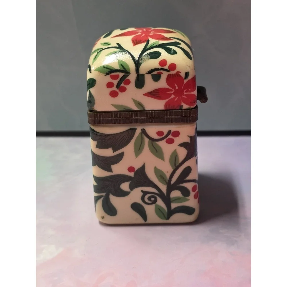 Vintage porcelain trinket box with hinged lid. Poinsettia and leaf design.